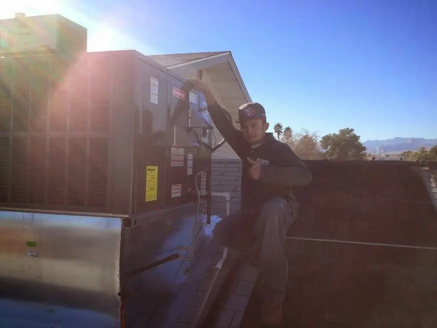 HVAC technician performing Air Duct Repair on a rooftop unit in Bernardsville